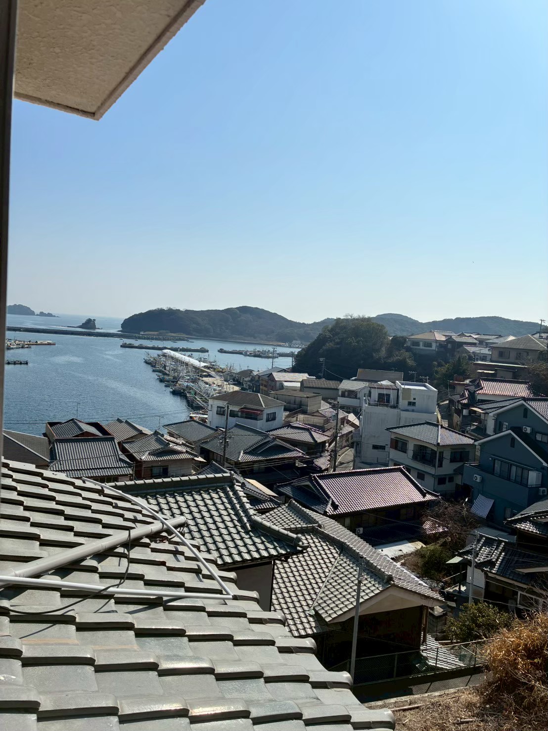 坊勢島の家から見える港町と海の風景写真